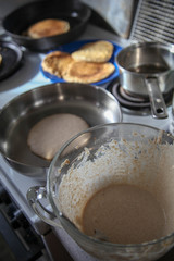 making pancakes and pancake batter in a frying pan 