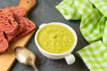 Broccoli soup and beet bread on blackboard table