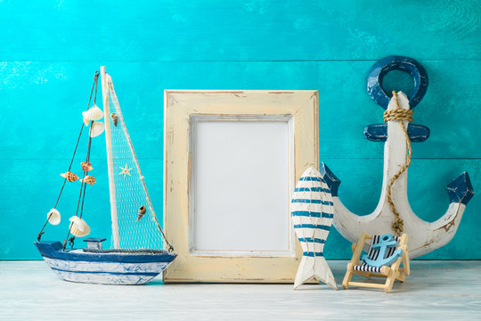 Frame and nautical summer decorations on wooden table