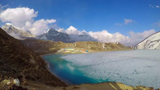 4K Time lapse of moving clouds above Gokyo Third Lake and Gokyo village in the spring in the Himalayas of Nepal. Travel, adventure, hiking and climbing concept.