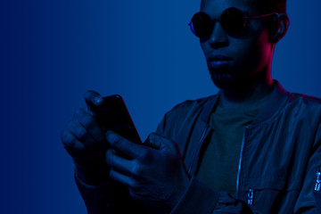 Stylish black guy using smartphone