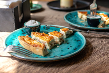 Chicken Quiche with mushrooms Recipe. Quiche Lorraine with chicken and Champignons and sauce on a blue plate on wooden table. Pie with chicken and mushrooms. Traditional French food