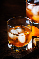 Old Fashioned - classic alcoholic cocktail with bourbon whiskey, bitter, cane sugar and ice in retro glasses on vintage bar counter, place for text