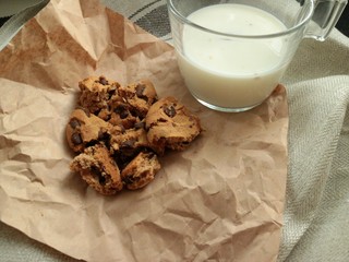 glass of milk with broken american cookies aside