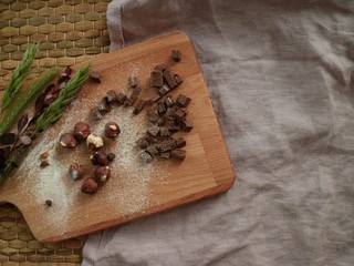 chocolate and nuts on wooden board and pink cloth