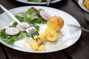 Vegan lunch. Baked potatoes, lettuce and radishes served on a white plate. Healthy lifestyle.