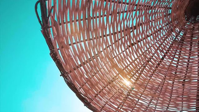 Straw beach umbrella and blue sky view. Sunlight shining through the umbrella 