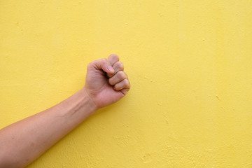 fist hand sign isolated on yellow background 