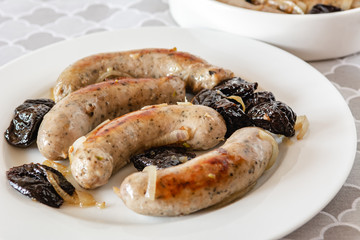 White sausage fried with onions and dried plums.