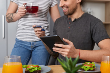 Crop couple doing online shopping together