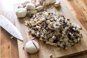 Cut mushrooms with a knife on a wooden cutting board