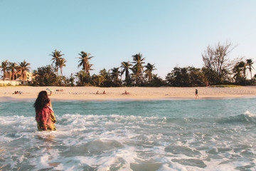 Girl with palm trees sunset in Caribbean