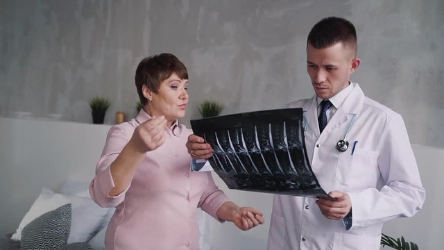Practitioner discussing x-ray picture with his patient