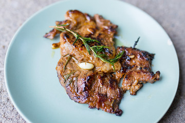 Round plate with grilled beef steak and rosemary