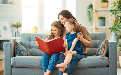 mother reading a book to her daughters