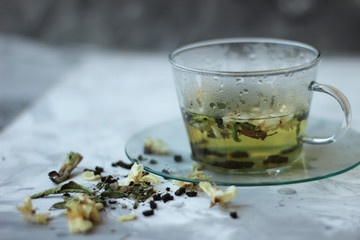 Detox food and drink healfhy lifestyle concept. Glass cup of green tea with jasmine on a gray background. Close