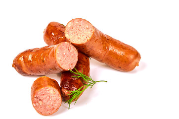 Fried pork sausages with greens in a pile on a white background. Grilled dill sausages on a light background.