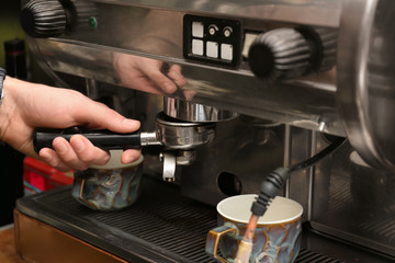 Barista preparing espresso using coffee machine, closeup