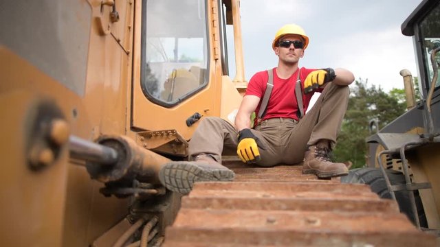 Construction Heavy Duty Equipment Worker. Bulldozer Operator Relaxing During His Job.
