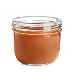 Jar of tasty caramel sauce isolated on white