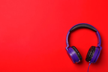 Stylish modern headphones on color background, top view. Space for text