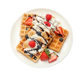Plate with yummy waffles, whipped cream and berries on white background, top view