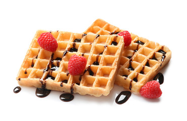 Delicious waffles with raspberries and chocolate syrup on white background