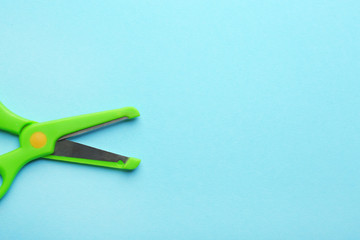 Training scissors on color background, top view. Space for text