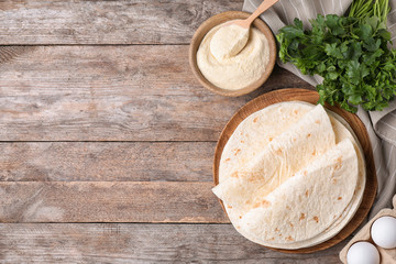 Flat lay composition with corn tortillas on wooden background, space for text. Unleavened bread