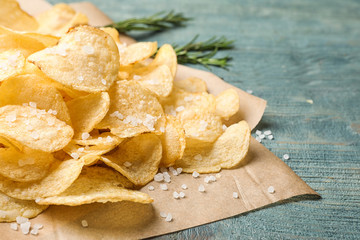 Delicious crispy potato chips on table, closeup with space for text