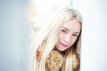 portrait of a sad thoughtful blonde girl near the old wall in the city, close-up, blue eyes