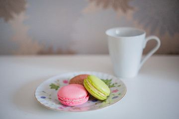 colorful macaroons and cup of coffee on wooden table