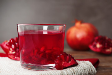 Glass of pomegranate jelly served on table, closeup. Space for text