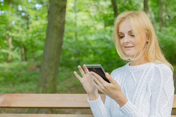 young woman with mobile phone in the park