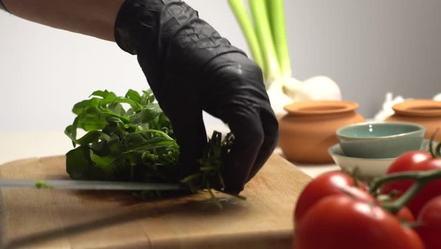 Cutting green rucola on the wooden board side view