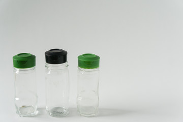 3 Multiple reusable spice seasoning jars; Green & black sprinkle lid tops for recycling campaign programs; Isolated kitchen item on horizontal white background; Blank empty copyspace; text copy room.