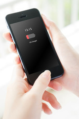 Female hand holding mobile phone with low charged battery screen