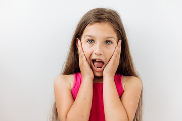 Surprised,shock ,unbelievable emotion. 9 year girl face portrait agaist white backgraund.