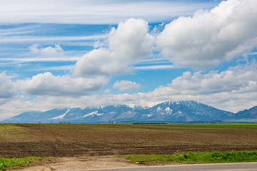 Obraz premium countryside landscape under blue sky and dramatic white clouds
