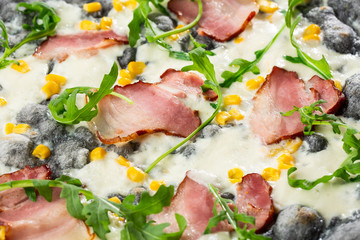 Tasty pizza with ham, corn, rucola and cheese.