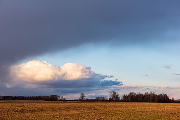 countryside landscape under blue sky and dramatic white clouds