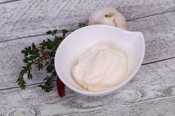 Mayonnaise sauce in the white bowl served thyme and garlic