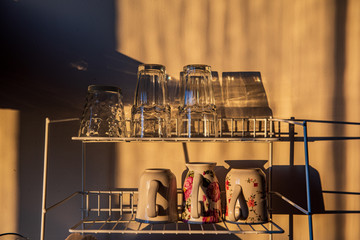 dishes and glasses on a dryer in kitchen in sunset light