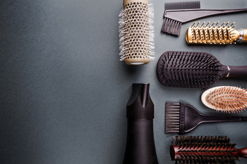 Various hair dresser tools on black background with copy space