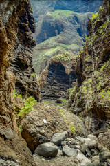Rocks in the Masca gorge, Tenerife, showing solidified volcanic lava flow layers and arch formation. The ravine or barranco leads down to the ocean from a 900m altitude.