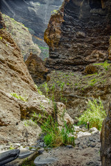 Rocks in the Masca gorge, Tenerife, showing solidified volcanic lava flow layers and arch formation. The ravine or barranco leads down to the ocean from a 900m altitude.