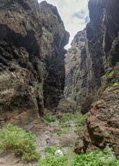 Rocks in the Masca gorge, Tenerife, showing solidified volcanic lava flow layers and arch formation. The ravine or barranco leads down to the ocean from a 900m altitude.