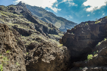 Rocks in the Masca gorge, Tenerife, showing solidified volcanic lava flow layers and arch formation. The ravine or barranco leads down to the ocean from a 900m altitude.