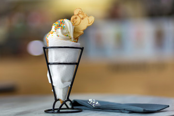 Ice cream cone dessert with cookies creative decoration topping on blurred light copy space background.