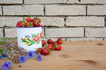 Czerwone truskawki w białym malowanym garnku © Monika